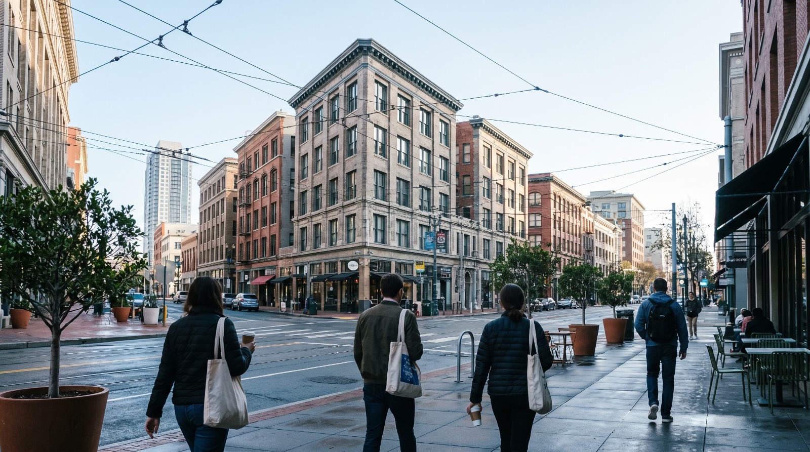 A SoMa and Mid-Market sidewalk in downtown San Francisco with active storefronts and pedestrians, part of a look at whether downtown is a place to live.