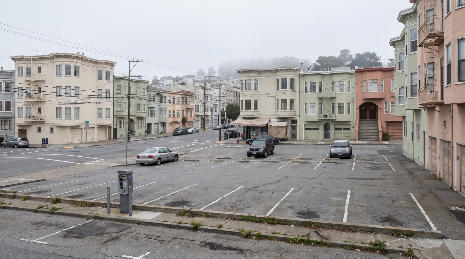 A city-owned surface parking lot in San Francisco's Inner Richmond ringed by flats, the kind of public land for housing the new report flags.