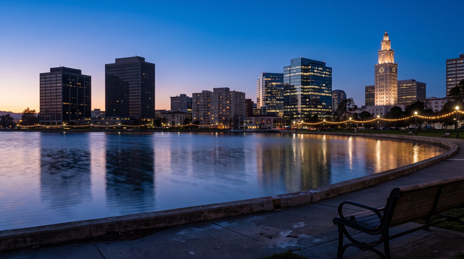 The downtown Oakland skyline reflected in Lake Merritt at dusk, the district AB 2074 would require the city to zone for 450-foot housing towers.