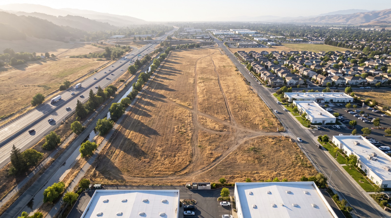 AI-rendered oblique aerial view of the empty field off Cochrane Road in Morgan Hill between Highway 101 and DePaul Drive, as it looks today