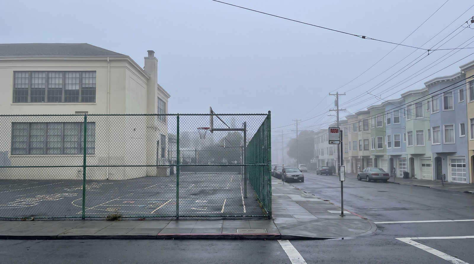 Foggy Richmond District street beside an empty public elementary schoolyard as SFUSD weighs ending its school lottery in San Francisco.