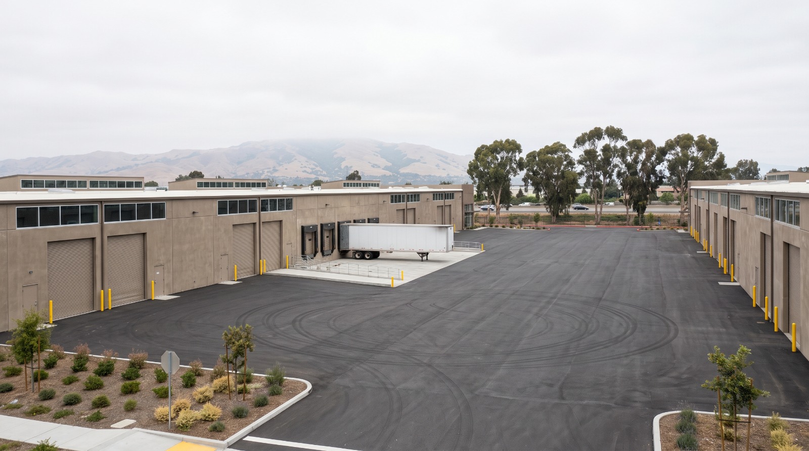 Low concrete advanced-manufacturing buildings on the Bayside industrial flats west of Interstate 880 in Fremont, California.