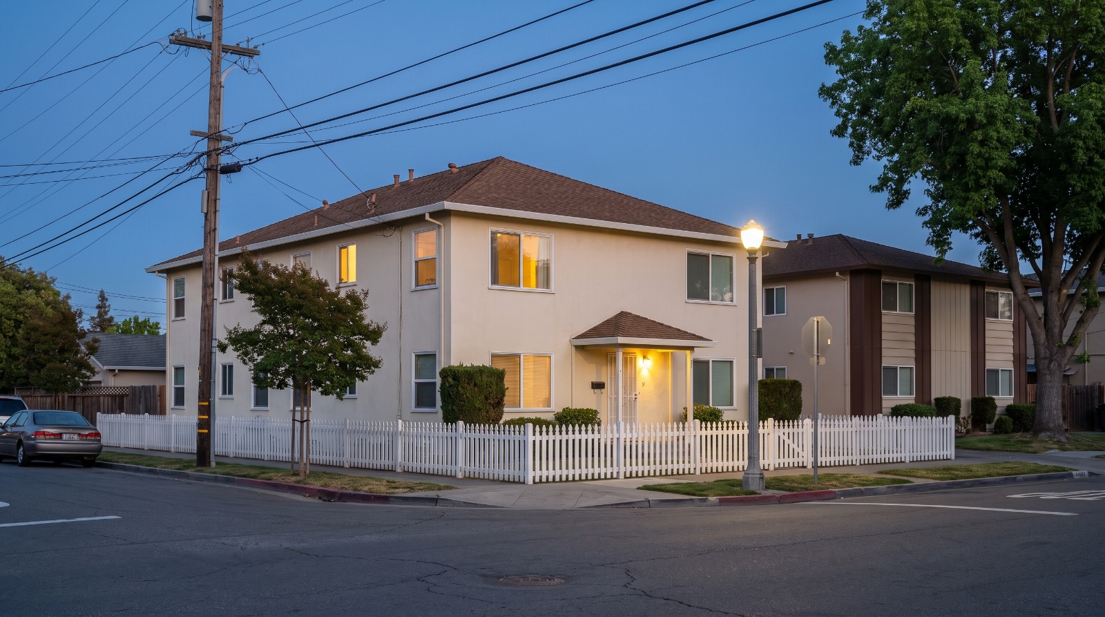 AI-rendered blue-hour view of older two-story apartment buildings on Buckeye Street in Redwood City's Staumbaugh-Heller neighborhood