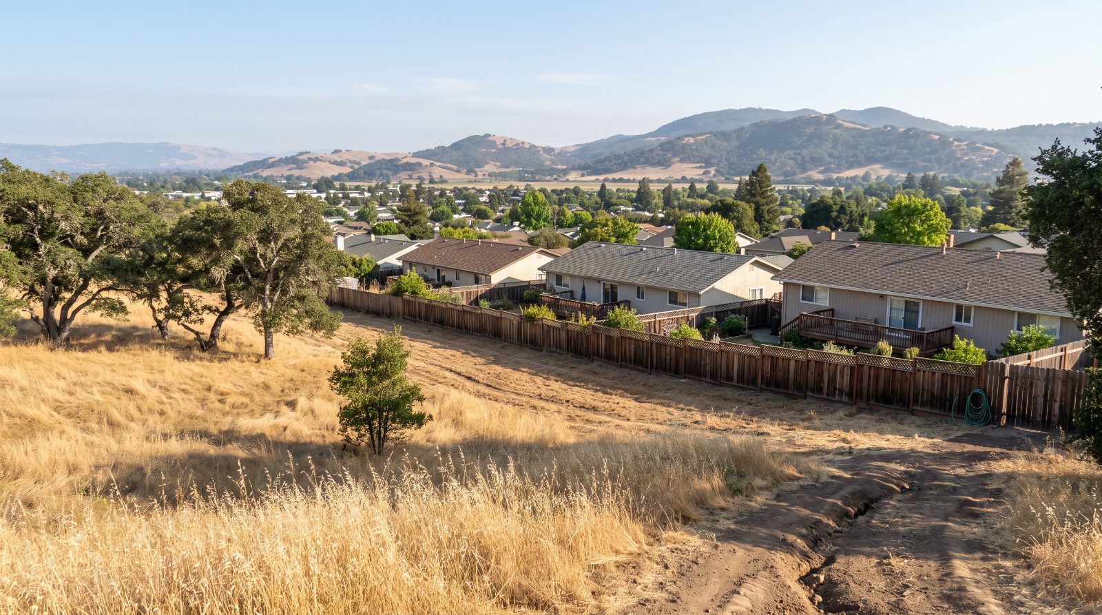Dry golden hills and a mowed fuel break behind San Marin homes in Novato, part of the city's fire hazard zones.