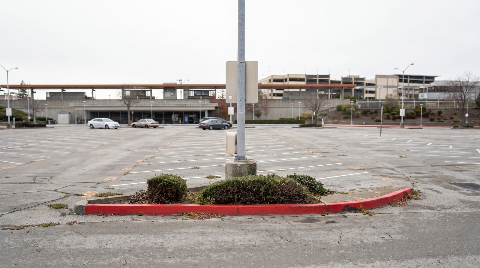AI-rendered view of the mostly empty east parking lot at Fremont BART Station, Fremont, with the elevated station platform behind it