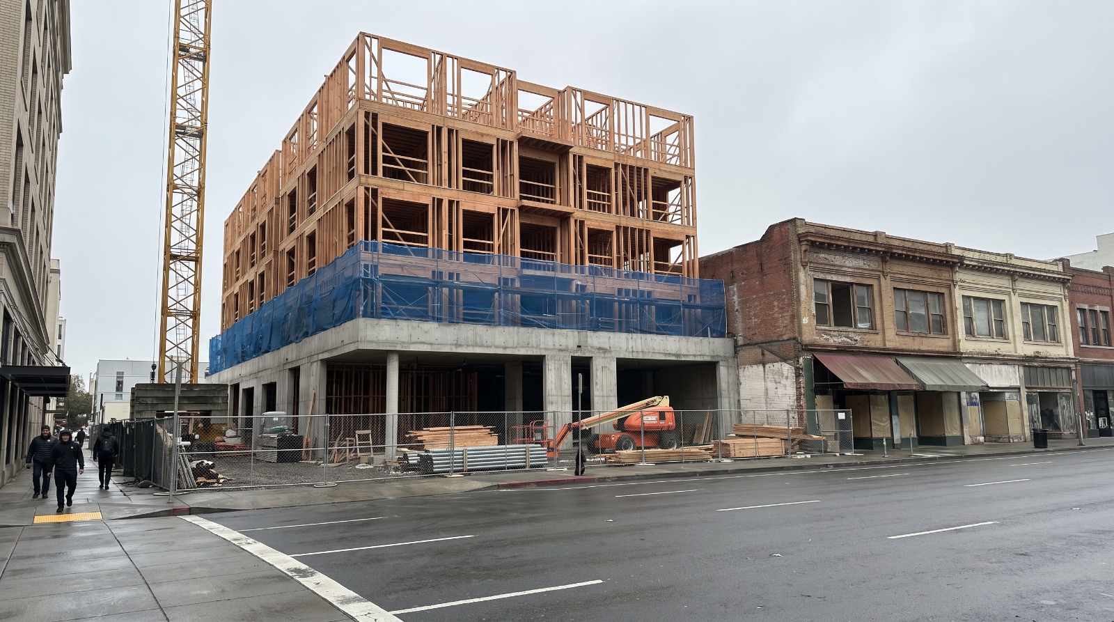 A mid-rise apartment building under construction in a Bay Area downtown, the kind of project the region needs far more of to meet its state housing goals