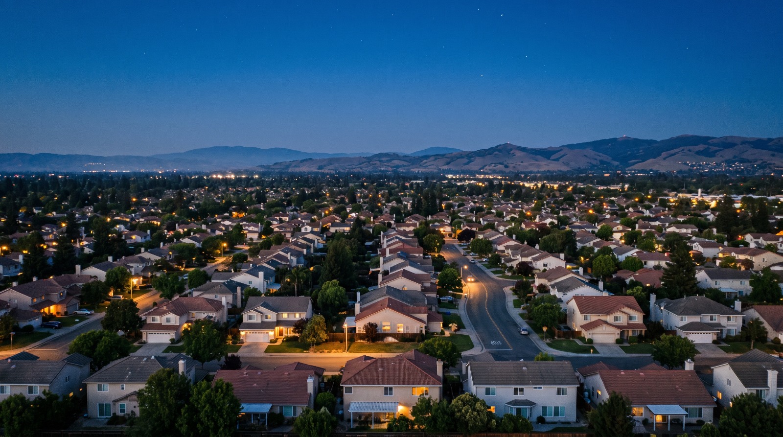 A twilight view across a South Bay single-family neighborhood toward the foothills, illustrating the Bay Area's two-speed 2026 housing market.