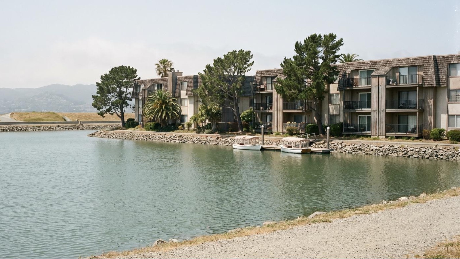 Three-story 1980s condominium buildings across a Foster City lagoon, in the city where the Foster City fire on Sea Spray Lane broke out.