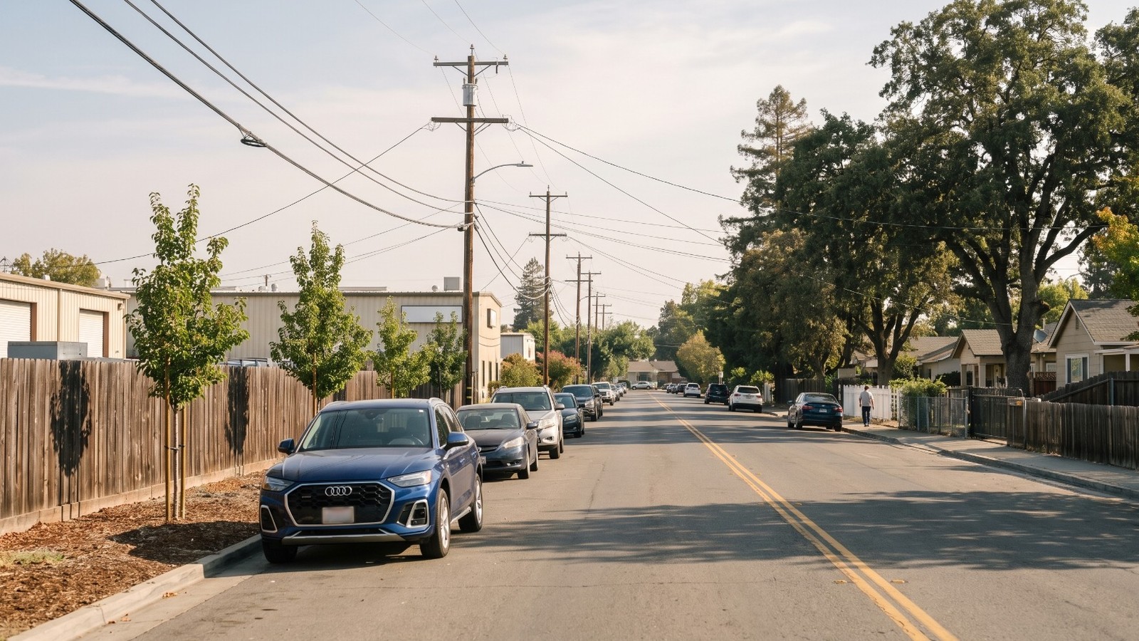 AI-rendered view of Edison Way in North Fair Oaks, San Mateo County, with low industrial buildings behind a fence on the left and homes under oaks on the right