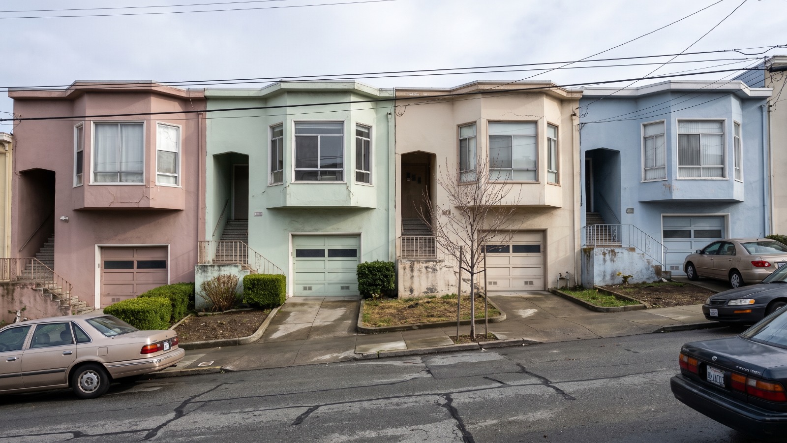 A row of pastel stucco row houses on an Excelsior side street in San Francisco, one of the neighborhoods where financed buyers can still compete in 2026.