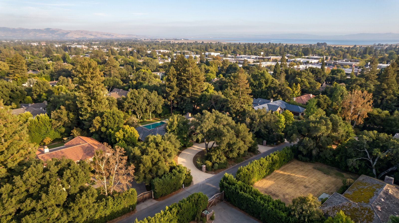 Aerial view of Atherton estates under oak and redwood canopy, a Bay Area town at the center of the Prop 40 billionaire tax debate.