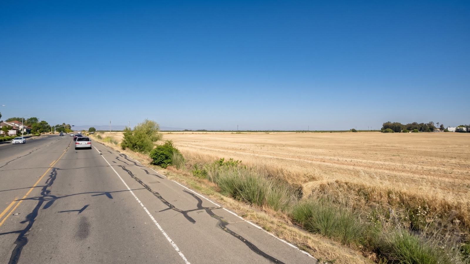 AI-rendered view of West Covell Boulevard on the northwest edge of Davis at midday, with the farm field in the draft West growth area on the right