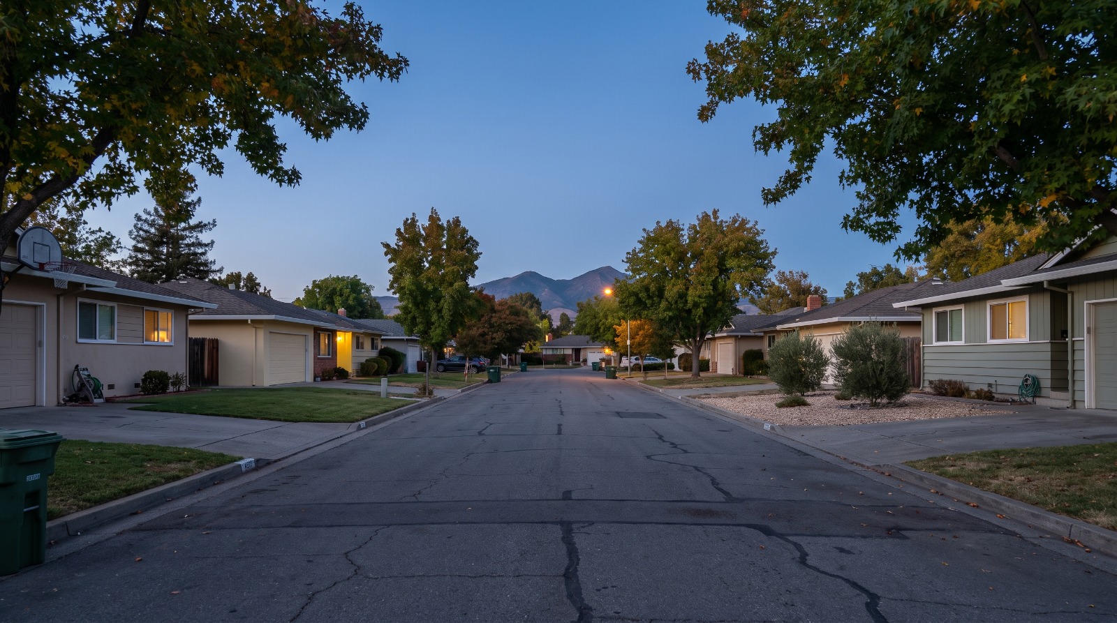A street of 1950s single-story ranch houses in Concord, California, with Mount Diablo on the horizon at dusk