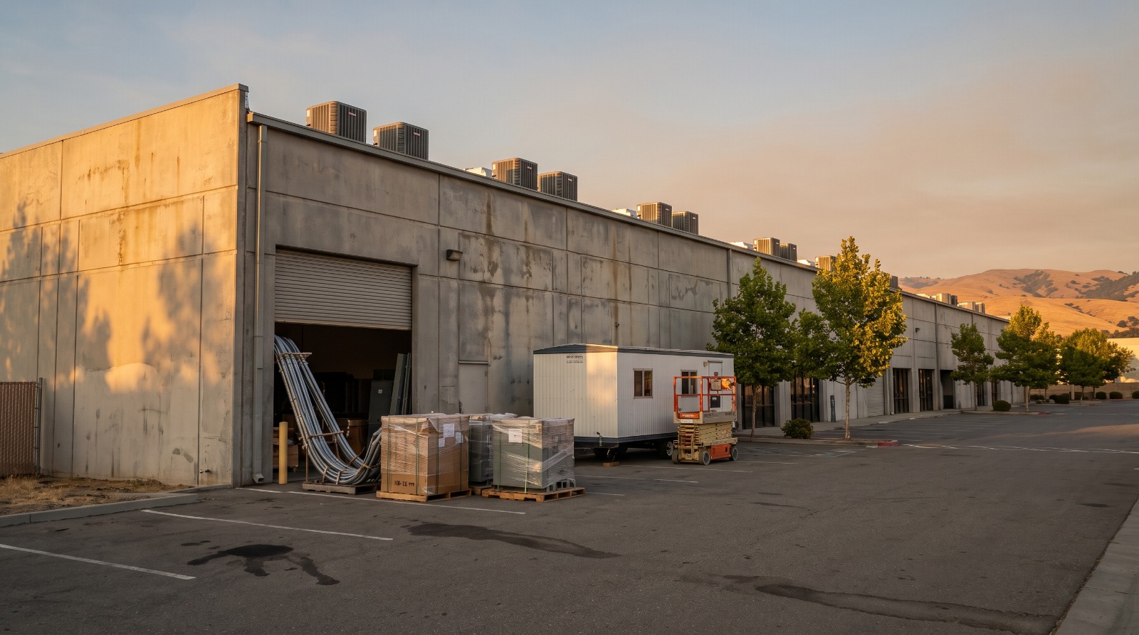 A single-story North San Jose R&D building mid build-out at dusk, the kind of site where MiTAC's San Jose AI server lab is going in.