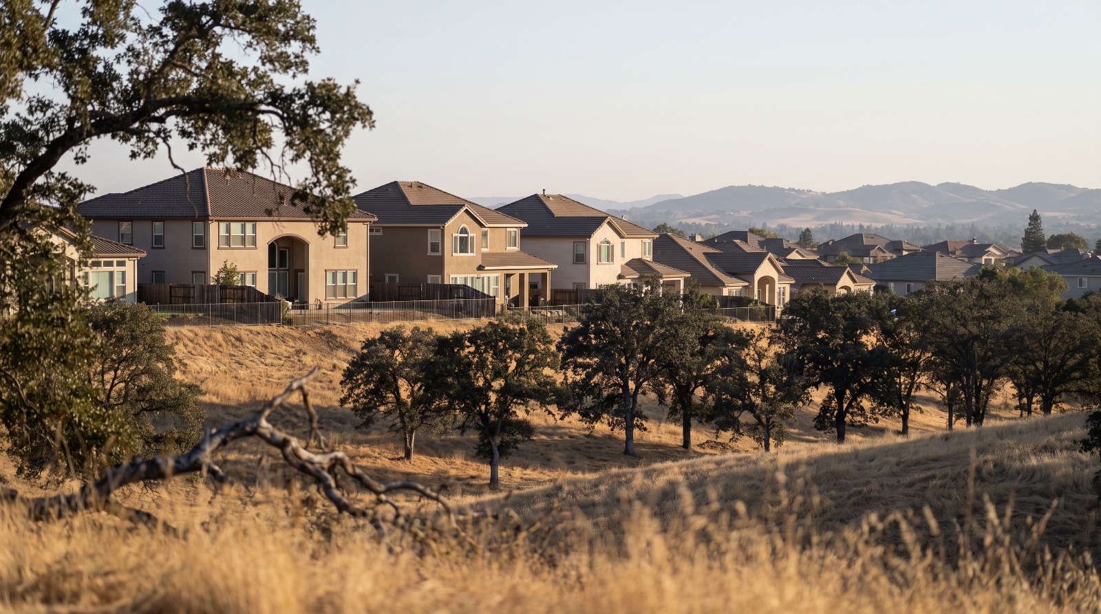AI-rendered telephoto view of Folsom hillside homes among oak trees in eastern Sacramento County, where FAIR Plan policies have grown fastest