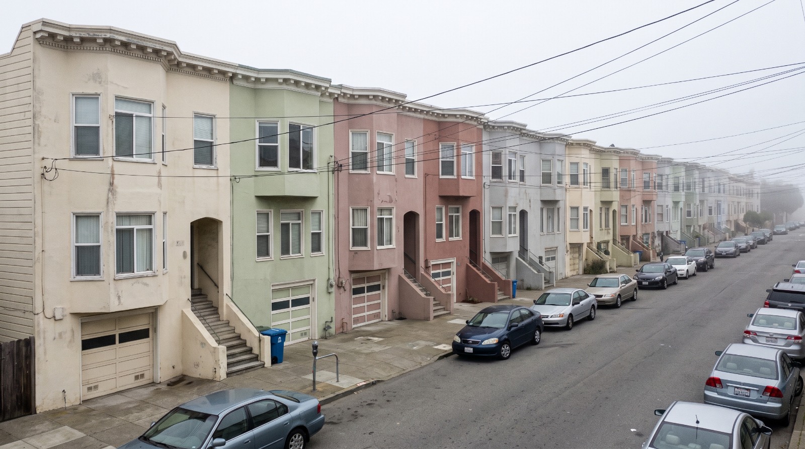 Two-story stucco row houses on a foggy Inner Parkside street in San Francisco, where a home recently sold for double its asking price.