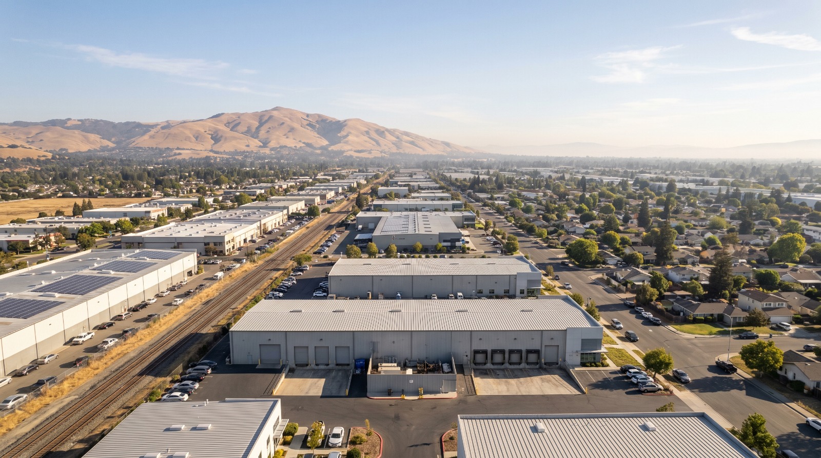 Advanced manufacturing buildings in the Warm Springs district of Fremont, the center of the city’s AI factory boom, with homes and Mission Peak beyond.